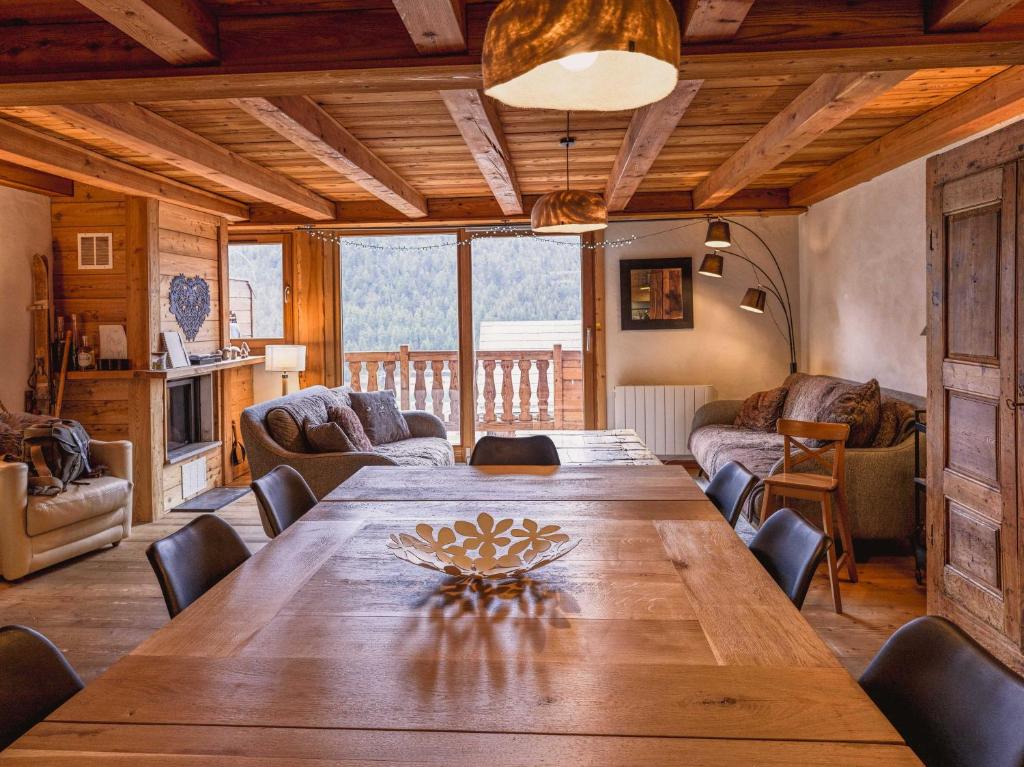 une salle à manger avec une grande table et des chaises en bois dans l'établissement Appartement en résidence standing, ski aux pieds et garage, à Montgenèvre