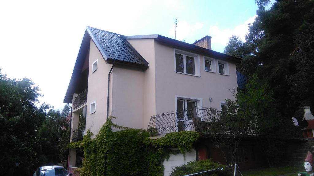 una casa blanca con techo negro en Stamford House, en Ostrzyce
