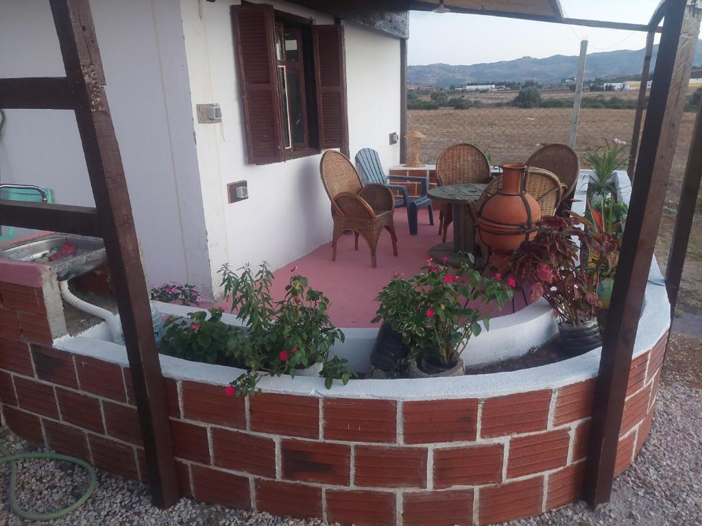 a patio with chairs and a table with plants at Chez le fermier Ferme pédagogique in Tetouan
