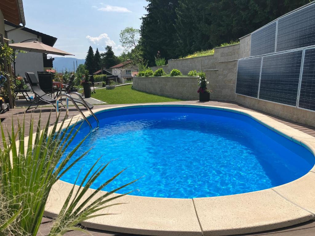a large blue swimming pool in a yard at Moderne Ferienwohnung am Wald in Siegsdorf