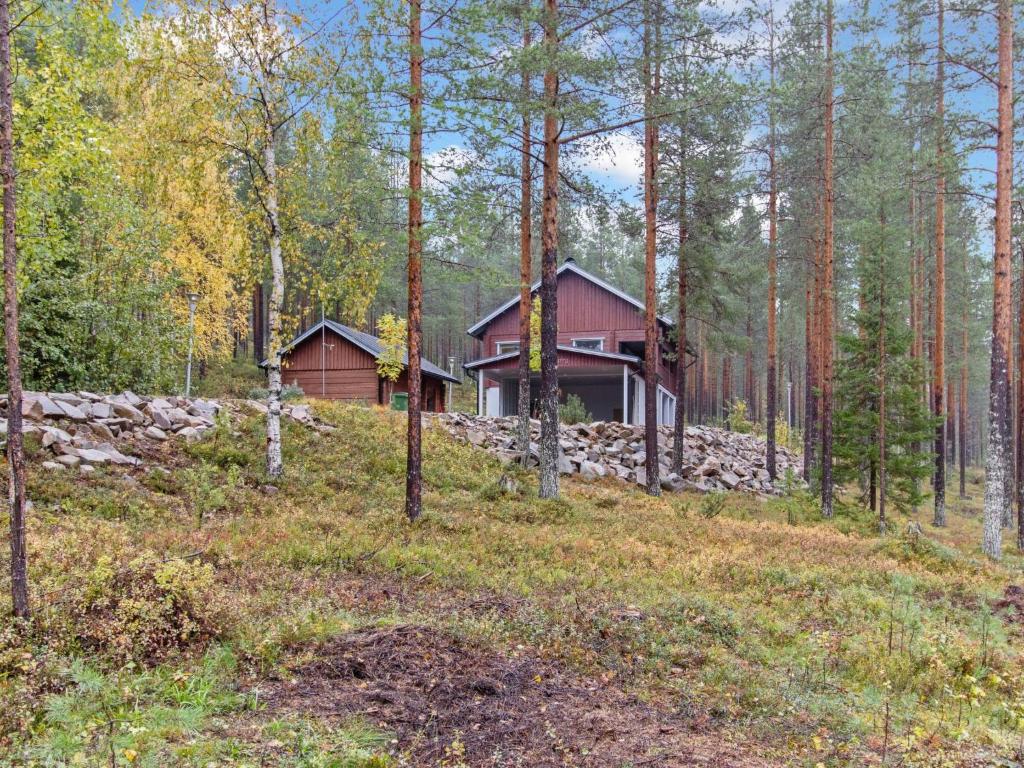 a house in the woods with a stone wall at Holiday Home Villa uuttu by Interhome in Pyhätunturi