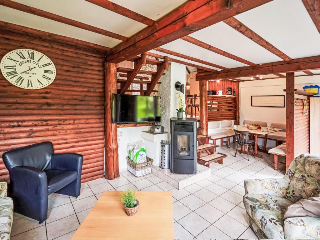 a living room with a fireplace and a clock on the wall at Apartment Klein und Fein by Interhome in Frankenau