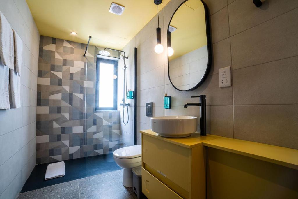 a bathroom with a sink and a toilet and a mirror at Eleven by Warren Collection in Sliema