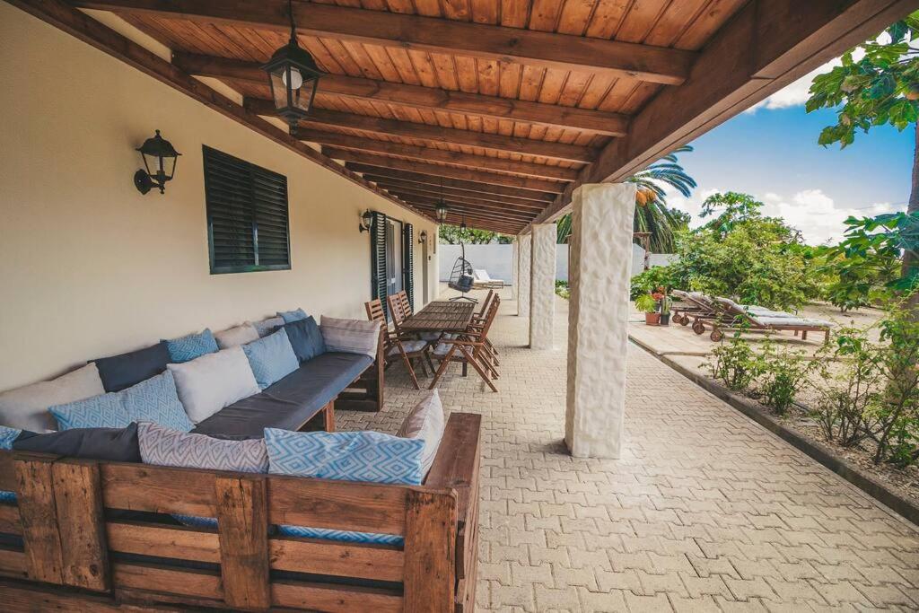 a patio with a couch and a wooden roof at Slowing Villas - Villa Âncora in Porto Santo