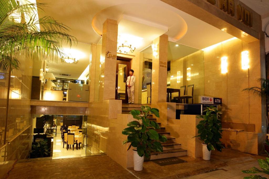 a man standing in the middle of a building at Hanoi L'Heritage Hotel & Gym - Spa in Hanoi