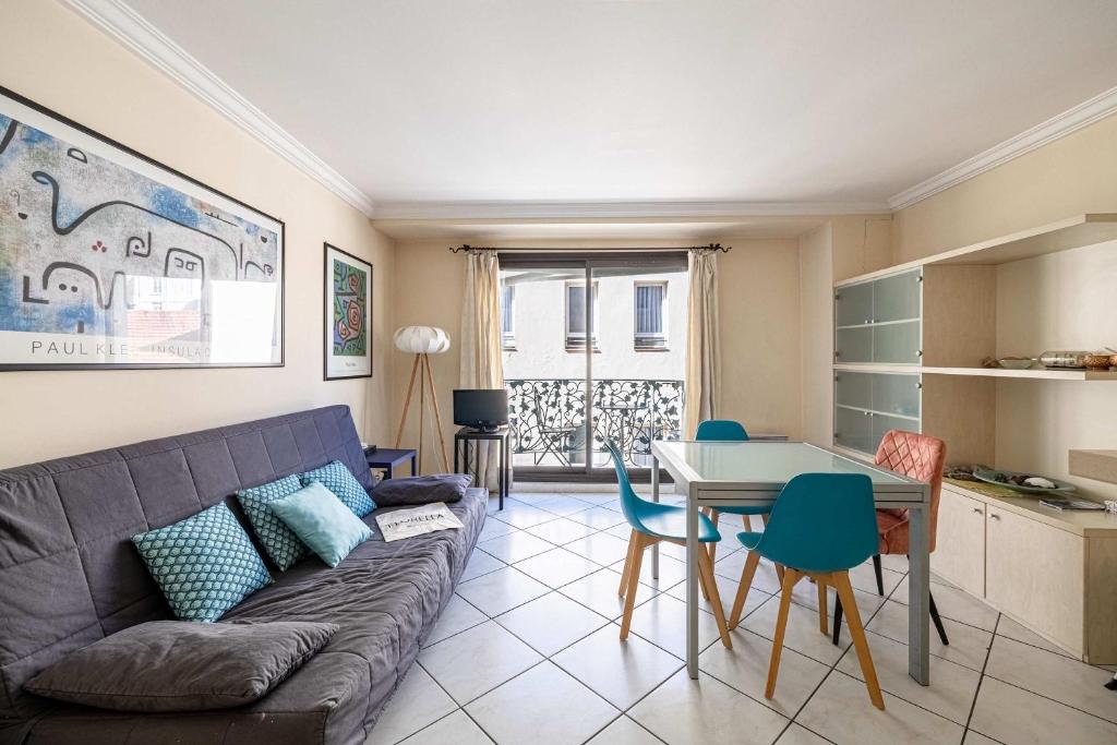 un salon avec un canapé et une table dans l'établissement LE CASANOVA avec balcon au cœur du centre-ville, à Cannes