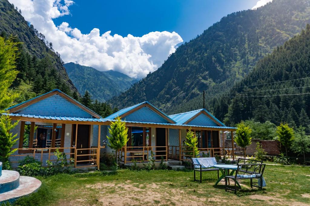 una casa in montagna con un tavolo di Lee Garden Himalayan Wooden Cottages a Kasol