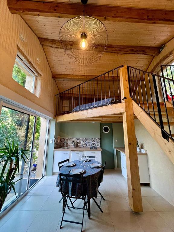 - une salle à manger avec une table et des lits superposés dans l'établissement La chambre du cantou, à Lautrec