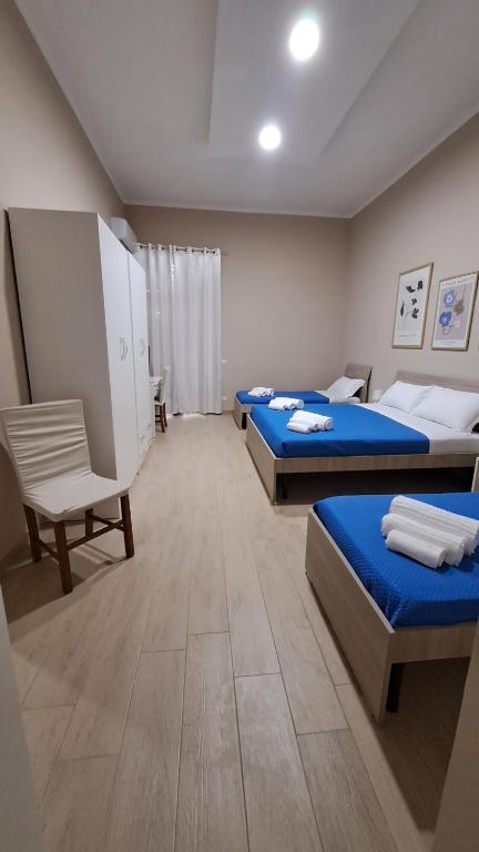 a room with two beds and a chair in it at Casa Vacanze Enrica House in Naples
