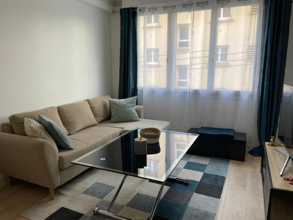 un salon avec un canapé et une table en verre dans l'établissement La Caliorne, à Rennes