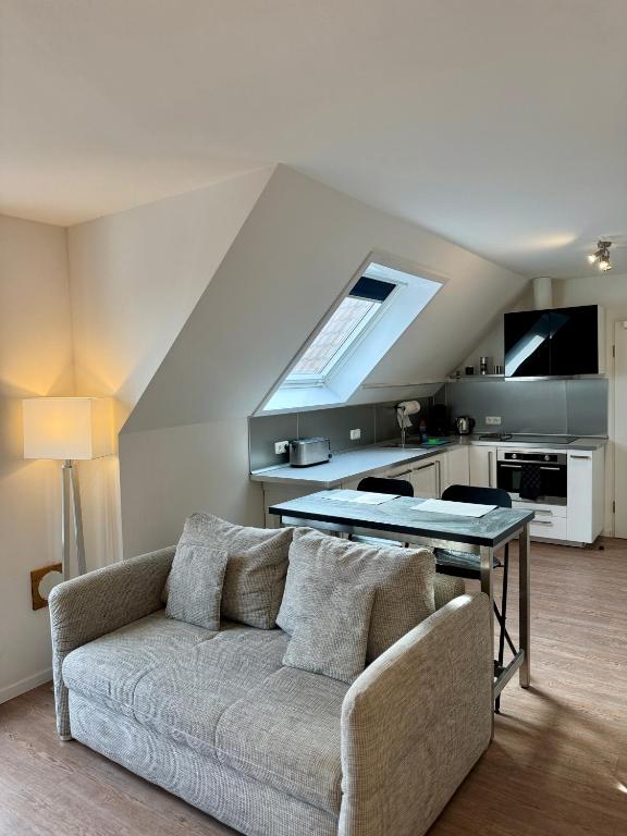 a living room with a couch and a kitchen at MEINpartments - Full service living Apartmenthouse in Wolfsburg
