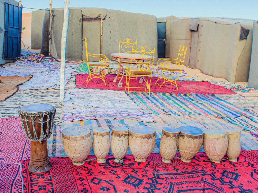 メルズーガにあるMerry Desert Campのテーブルと椅子、ラグが備わる客室です。
