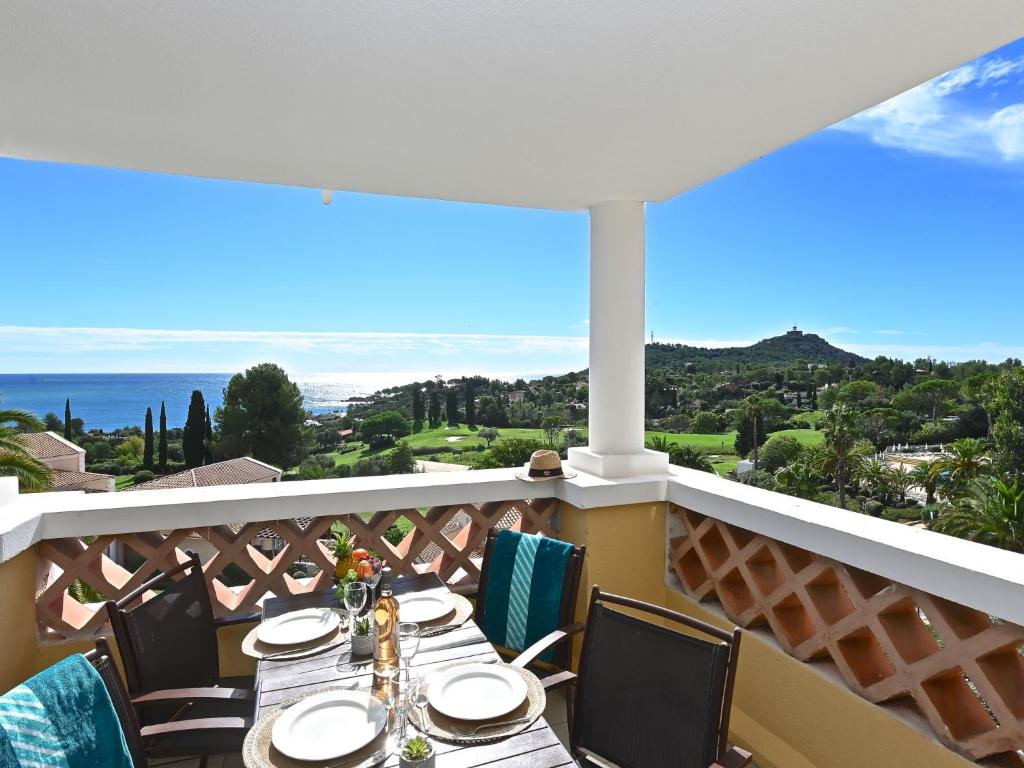 a table on a balcony with a view of the ocean at Apartment Village Cap Estérel - Le Village-80 by Interhome in Agay - Saint Raphael