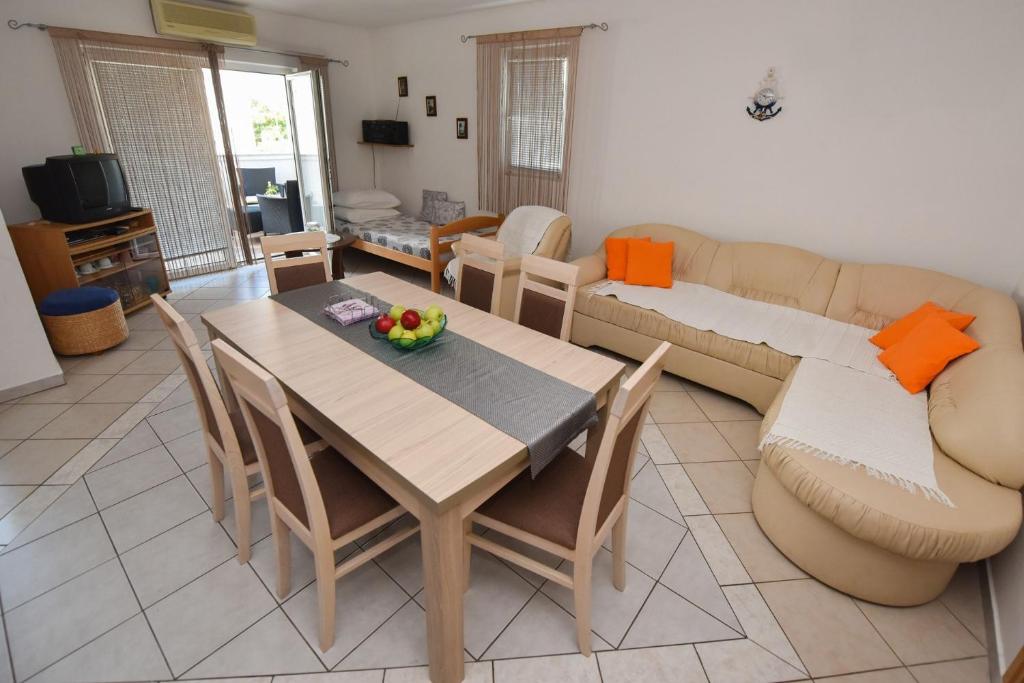 salon ze stołem i kanapą w obiekcie Apartment Kety w Novalji