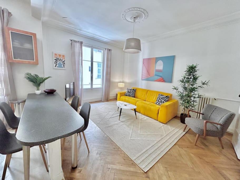 un salon avec un canapé jaune et une table dans l'établissement Charmant 3P en centre ville, spacieux et calme, à Nice