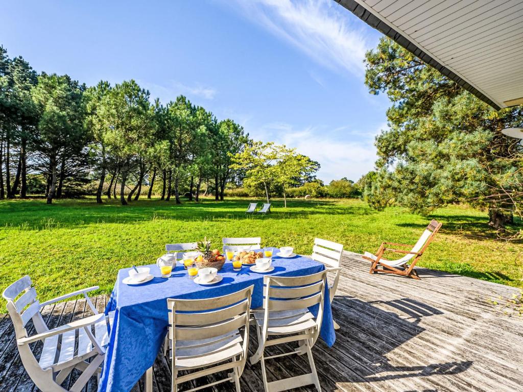 a table with a blue table cloth and white chairs at Holiday Home Le Prado-2 by Interhome in Saint-Philibert