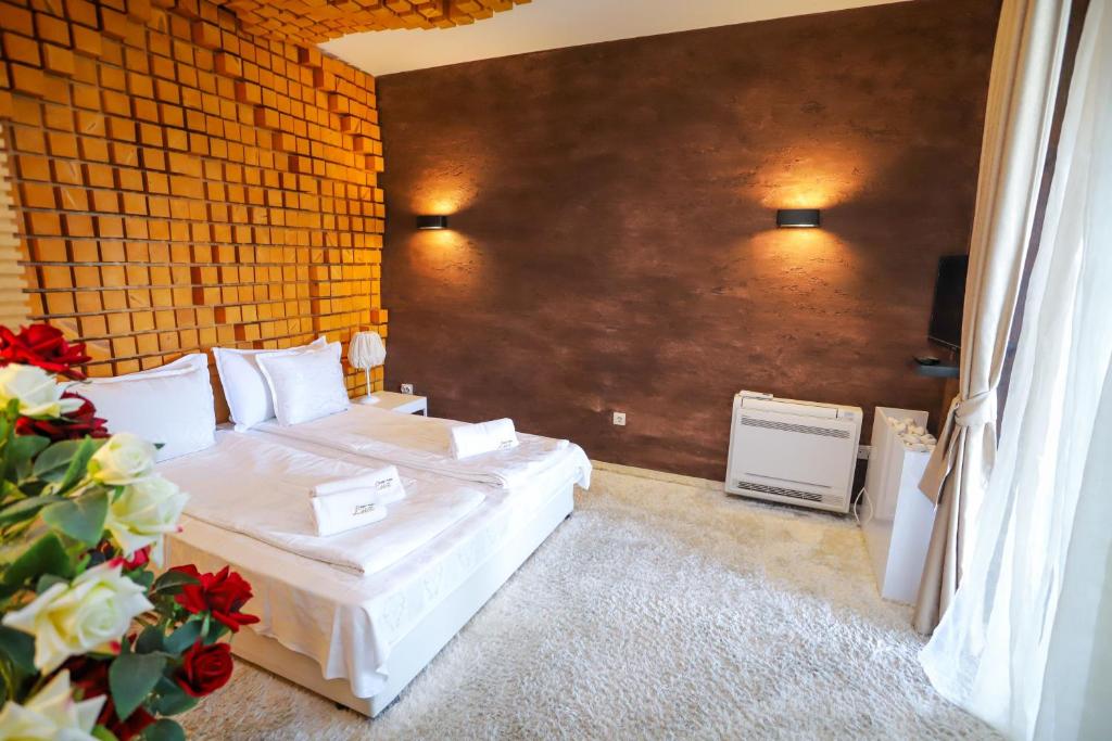 a bedroom with two beds and a wall at Deluxe House Glavatarski Han in Glavatartsi