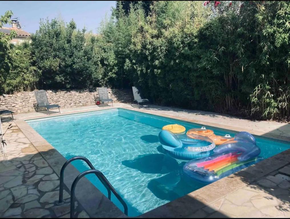 - une piscine avec un radeau et des jets gonflables dans l'établissement Charmante maison climatisée avec piscine privée, à Avignon