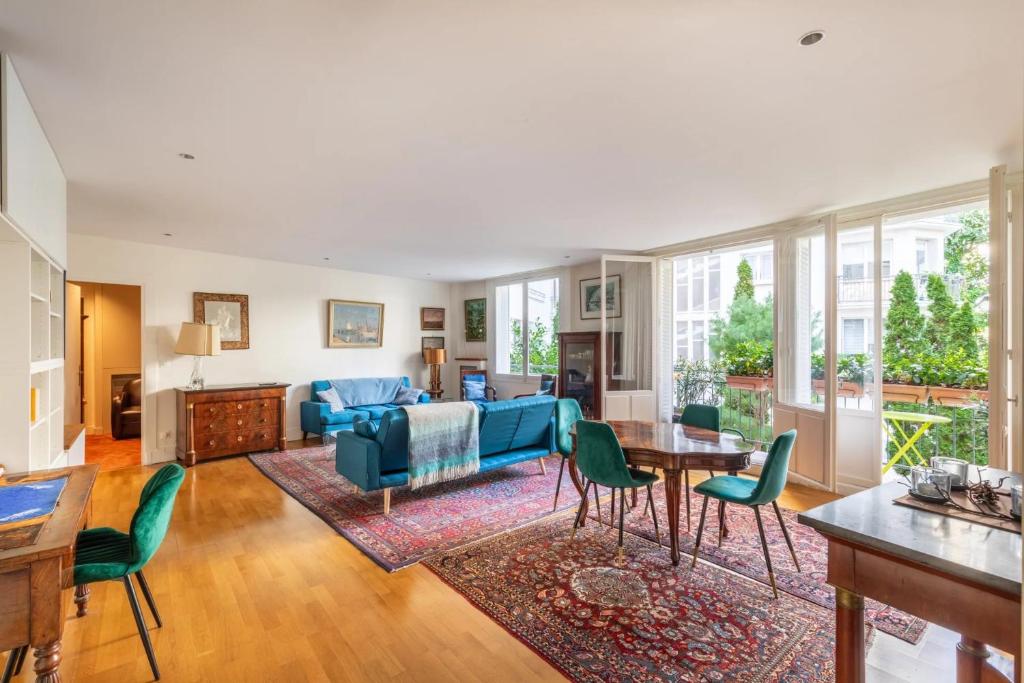 - un salon avec un canapé bleu et des fauteuils verts dans l'établissement Paris chic Trocadero, à Paris