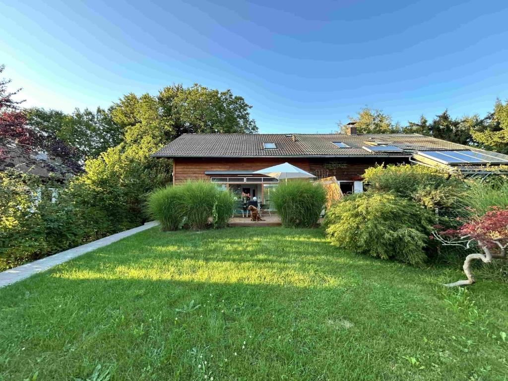 a house with a yard in front of it at Tu Casa Chiemsee Ferienhaus in Gstadt am Chiemsee