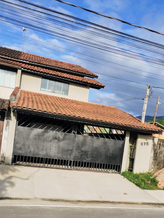 a white house with a red roof at Casa de praia in Bertioga