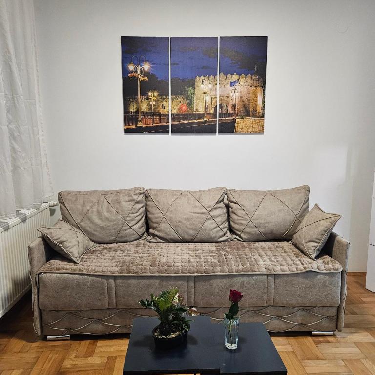 a living room with a couch and a picture on the wall at ONLY 4 YOU apartment in Niš