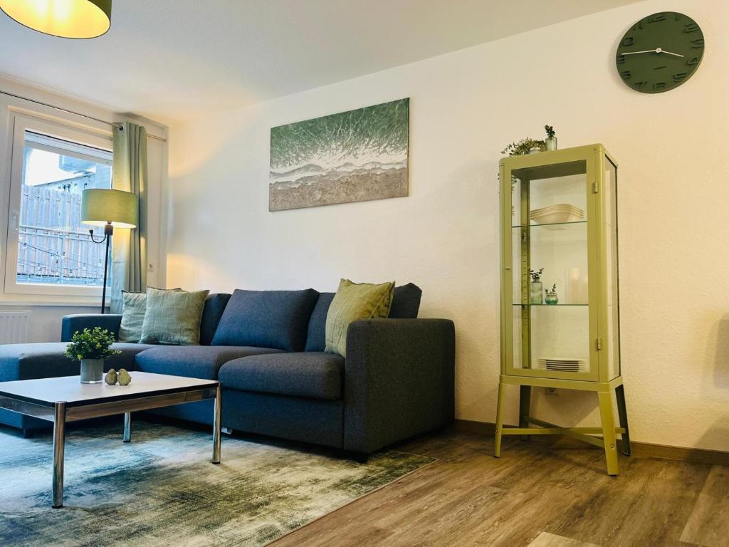 a living room with a blue couch and a table at Ferienwohnung Stern in Goslar