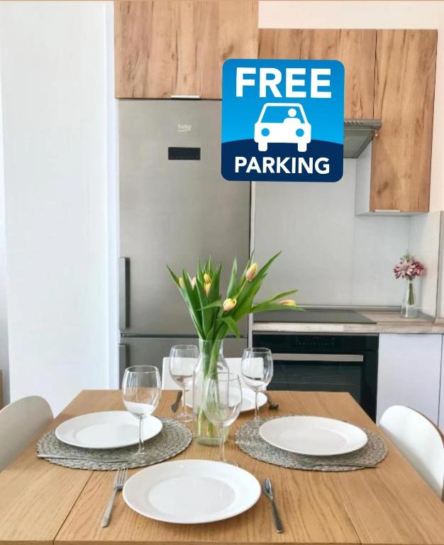 a table with plates and glasses and a sign that reads free parking at Apartament Czechowska Luxury in Lublin