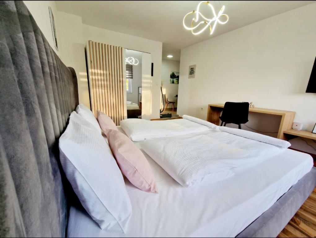 a bedroom with a bed with white sheets and pink pillows at Infinity Apartment & Free Wifi & Free Parking in Sarajevo