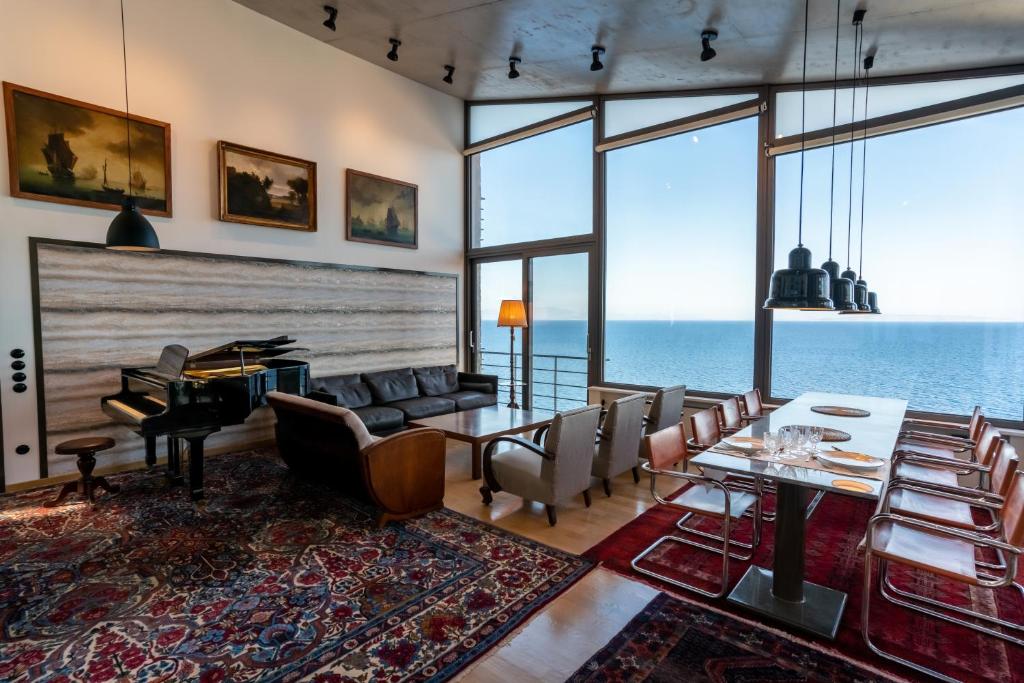a living room with a table and chairs and the ocean at LEONIDIONHOUSES - The Lykoskufi Villas in Tiros
