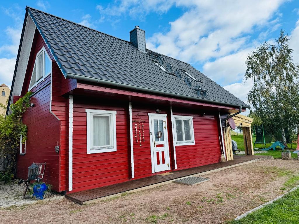 a red house with a white door at VillaHarmony wartet auf Familien mit Hund! in Lommatzsch