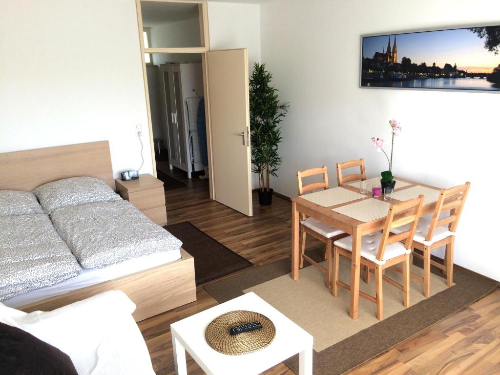 sala de estar con cama, mesa y sillas en Apartment Westside, en Regensburg