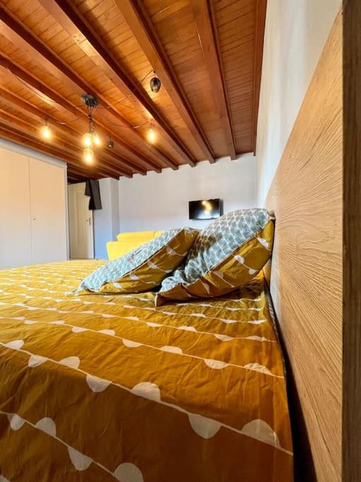 un lit avec des oreillers dessus dans une chambre dans l'établissement Le Studio des Marmottons, cœur de village, à Bonne