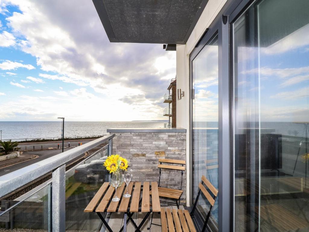 balcón con banco y vistas al océano en 7 Warren Edge Close, en Bournemouth