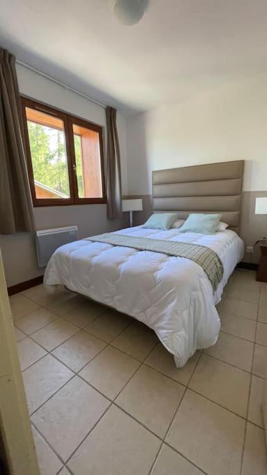 une chambre avec un grand lit et une fenêtre dans l'établissement VALBERG aux pieds des pistes et centre station, à Valberg