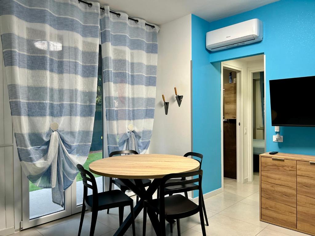 a dining room with a table and chairs and a window at Appartamento Conchiglia-Immobili e Soluzioni Rent in Lido Adriano
