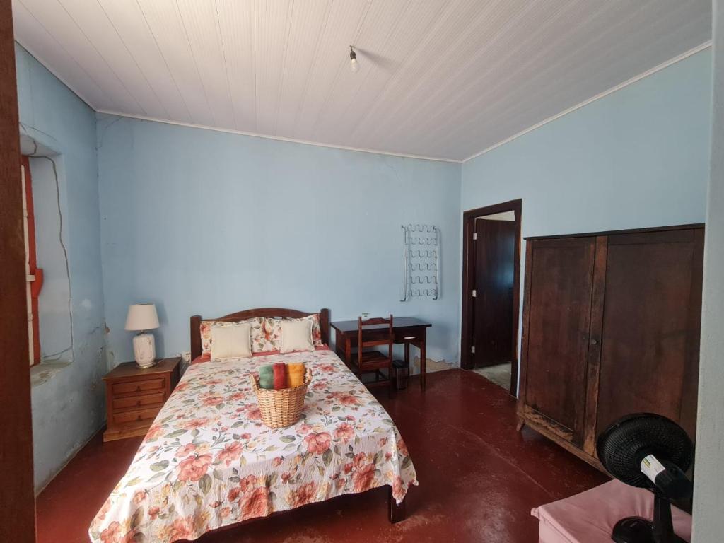 a bedroom with a bed and a table in it at MAEVE hospedaria - Suíte Campo in Goiás