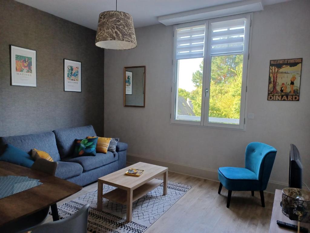 un salon avec un canapé bleu et une table dans l'établissement La belle époque, à Dinard