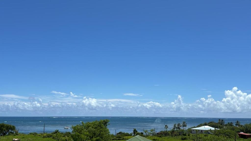 a view of the ocean from a house at VILLA ODYSSEE 3 étoiles VUE MER Exceptionnelle, Spot VOILE, new Climatisation in Le Vauclin