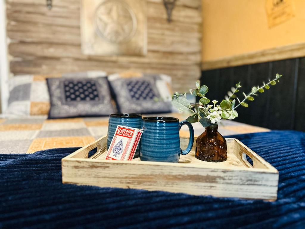 un vassoio di legno con due tazze e un vaso con fiori di Acorn Hideaways Canton Rustic Old West Frontier Suite a Canton