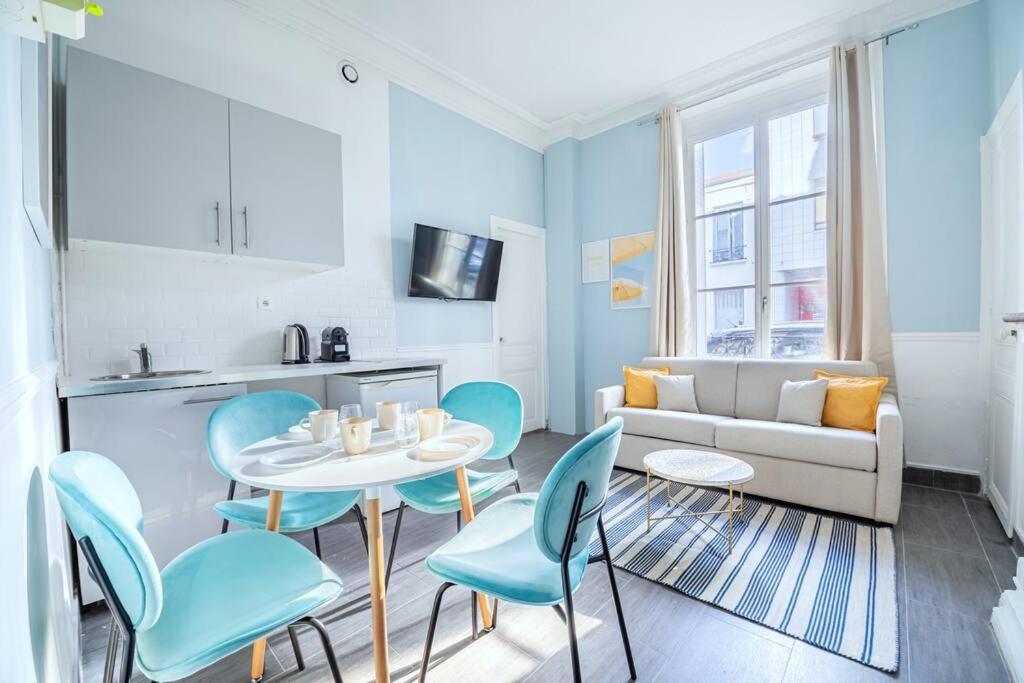 un salon avec une table, des chaises et un canapé dans l'établissement Appartement relaxant #Montparnasse 4 personnes, à Paris