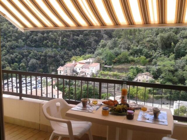 une table avec de la nourriture au sommet d'un balcon dans l'établissement Amélie les bains Exposition SUD Gorges du Mondony 6éme étage, à Amélie-les-Bains-Palalda