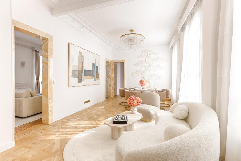 un salon blanc avec un canapé et une table dans l'établissement Artistic Luxury 3-Bedroom Apartment - Champs-Élysées, à Paris