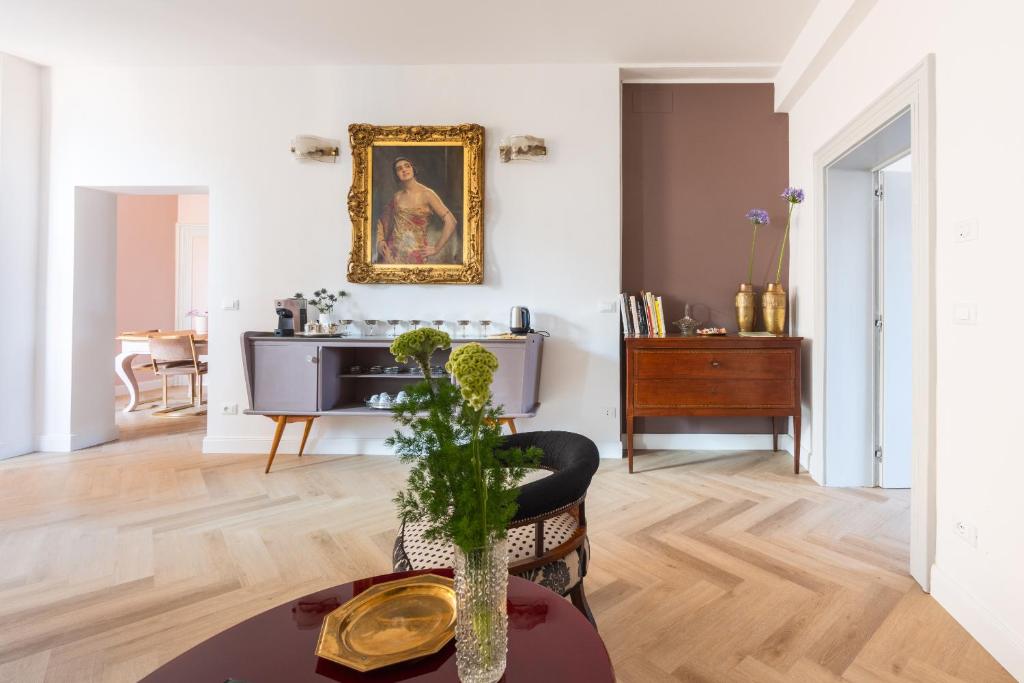 una sala de estar con una mesa y una pintura en la pared en Artieri Suites, Piazza Maggiore, en Bolonia