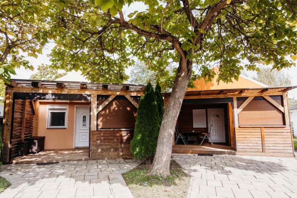 a house with a tree in front of it at Holiday home Isabella in Terme Čatež in Čatež ob Savi