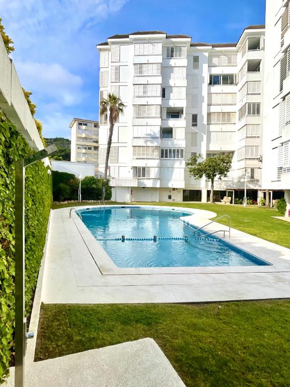 a swimming pool in front of a building at LA MER BLEUE, Boutique Apartament with free parking, full equipped in Fenals Beach in Lloret de Mar