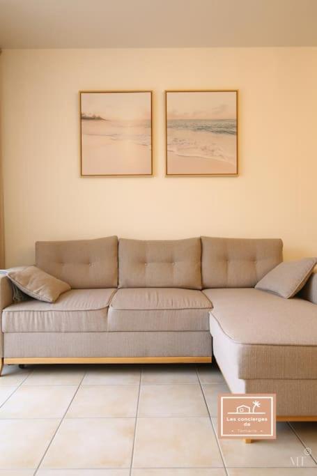 - un salon avec un canapé et deux photos sur le mur dans l'établissement L'évasion seynoise, à La Seyne-sur-Mer