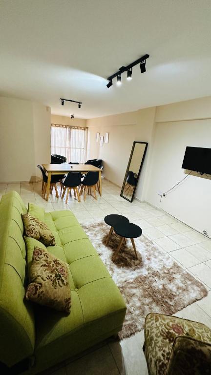 a living room with a green couch and a table at Bv San Juan - Nva Cba in Córdoba