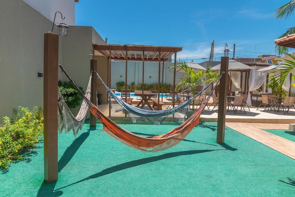a hammock on the side of a house at Pousada Maré do Francês in Praia do Frances
