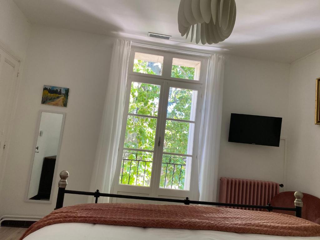 Televízia a/alebo spoločenská miestnosť v ubytovaní Maison de maître Les toiles à Elise